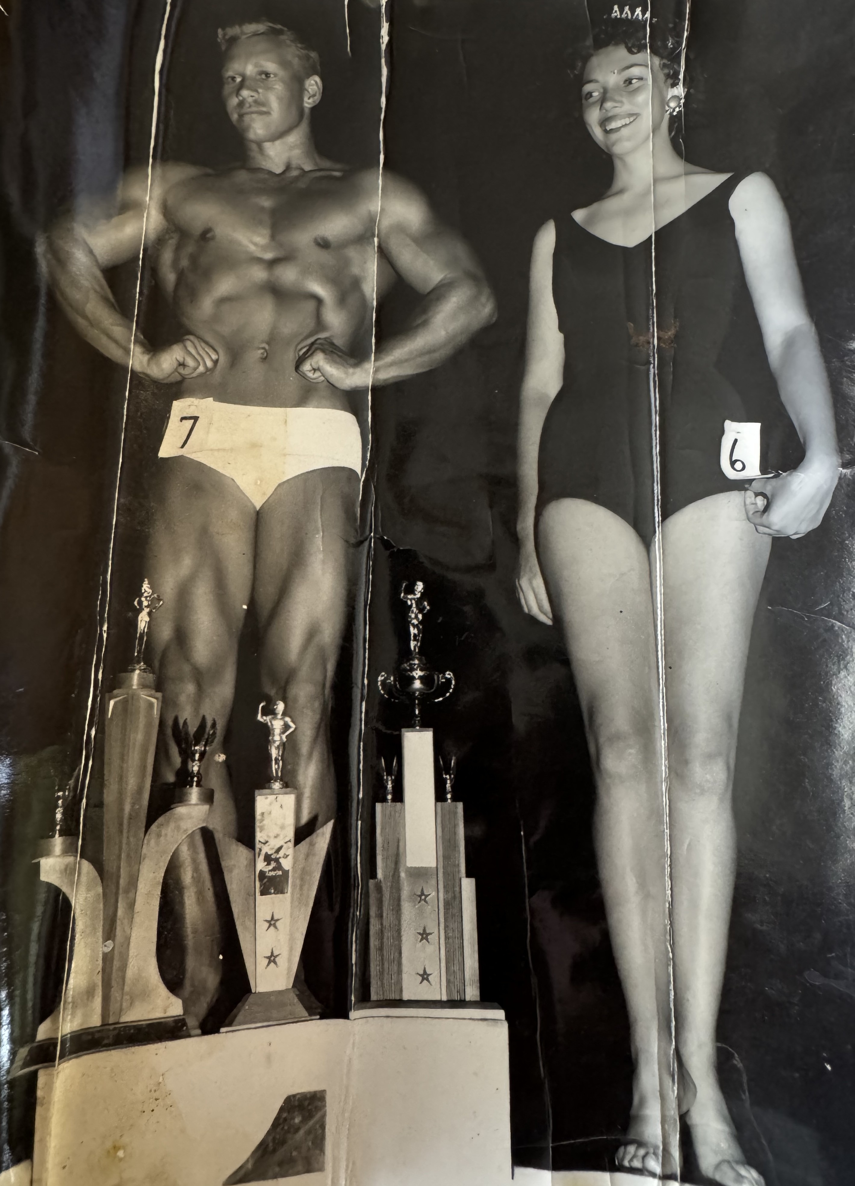 Gail Crick on stage with competition trophies alongside a beauty pageant contestant
