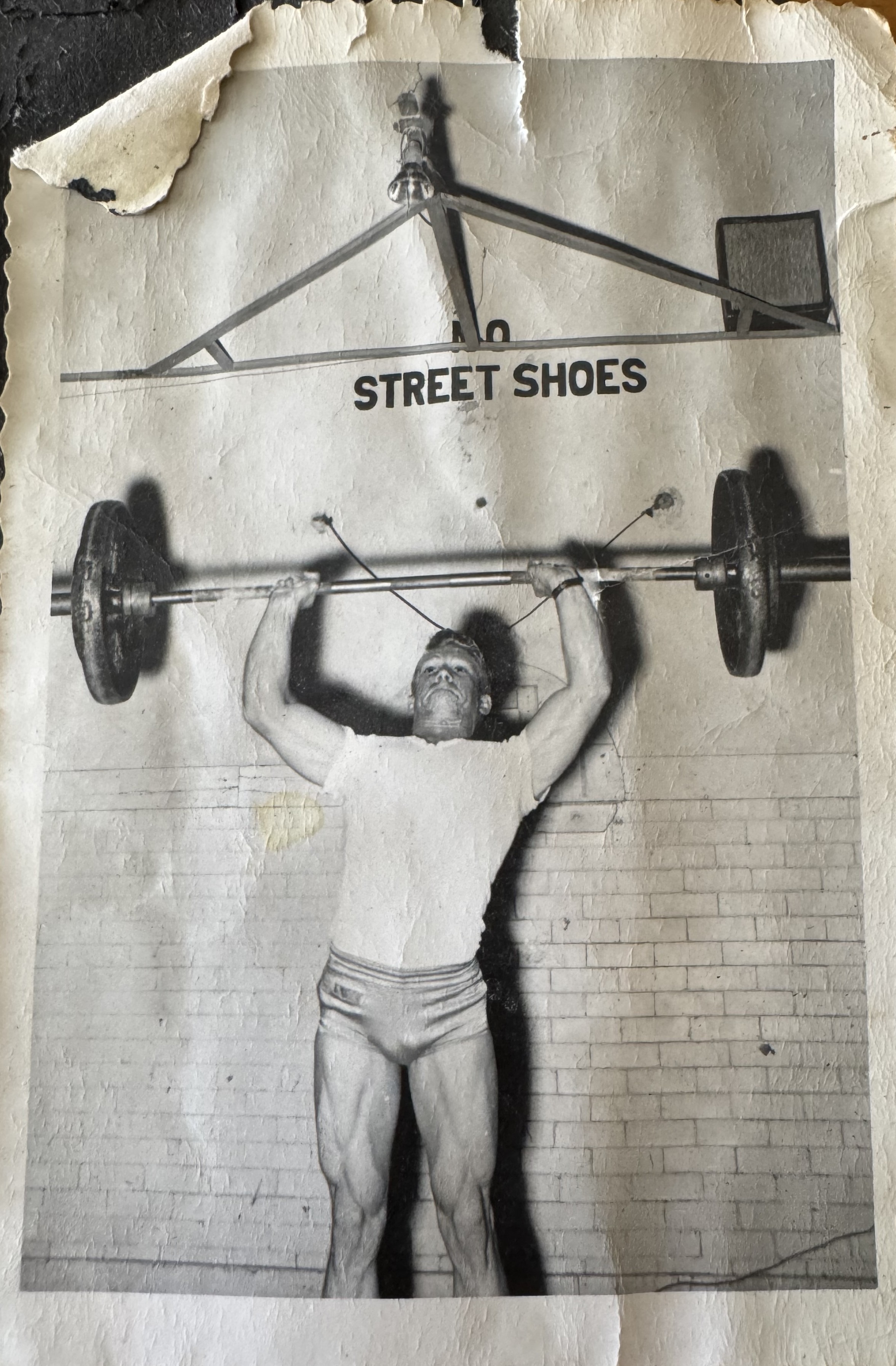 Gail Crick performing an overhead barbell lift in the gym