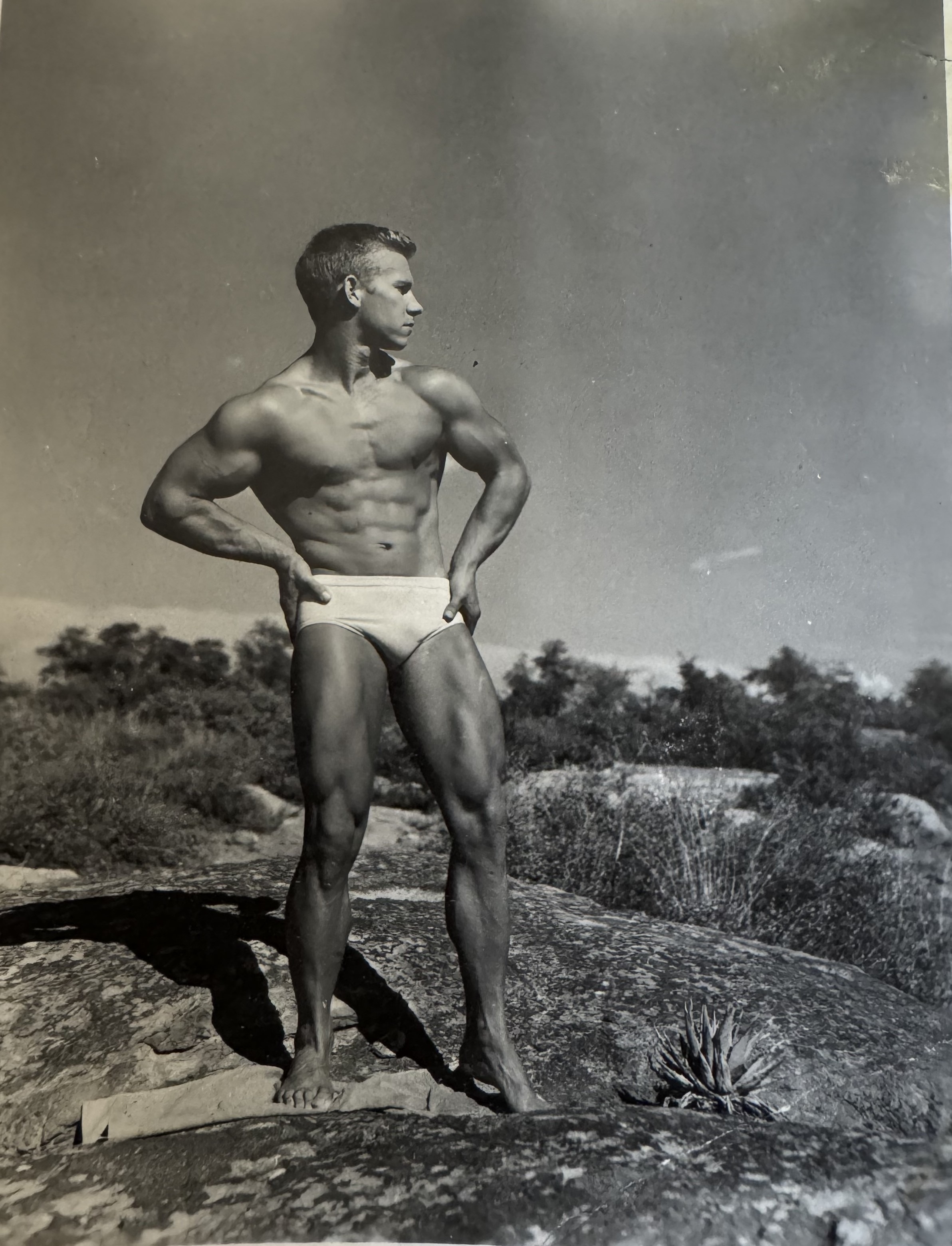 Gail Crick leaning against a rock, hands behind head