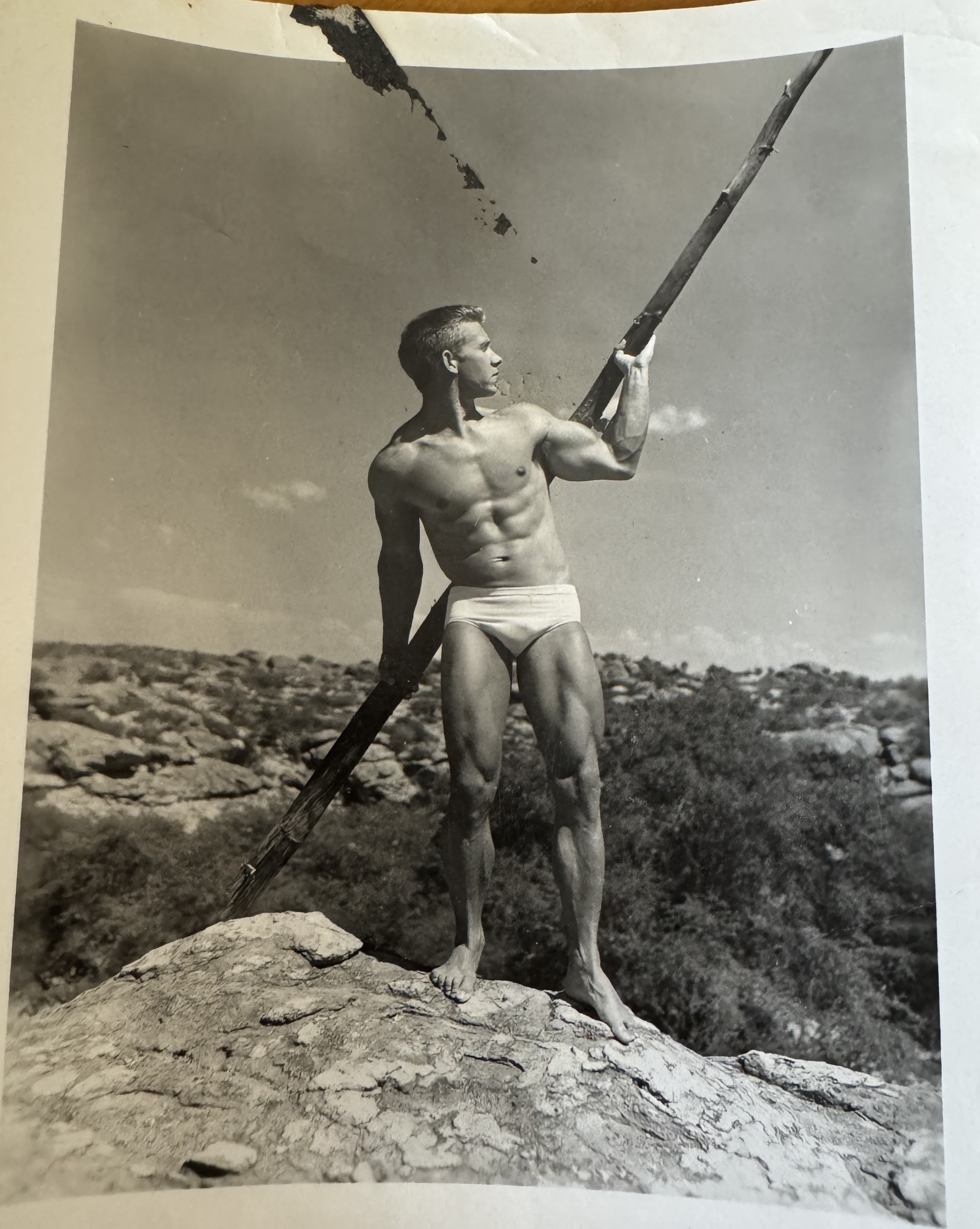 Gail Crick posing with a long wooden staff on Arizona rocks