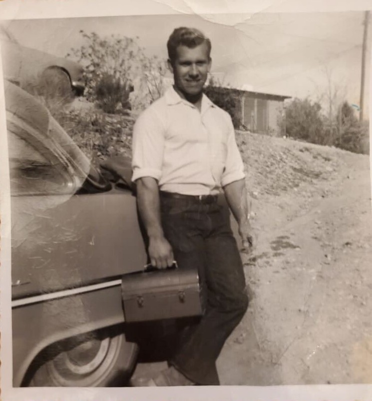 Gail Crick leaning against his car with lunchbox, headed to the mine